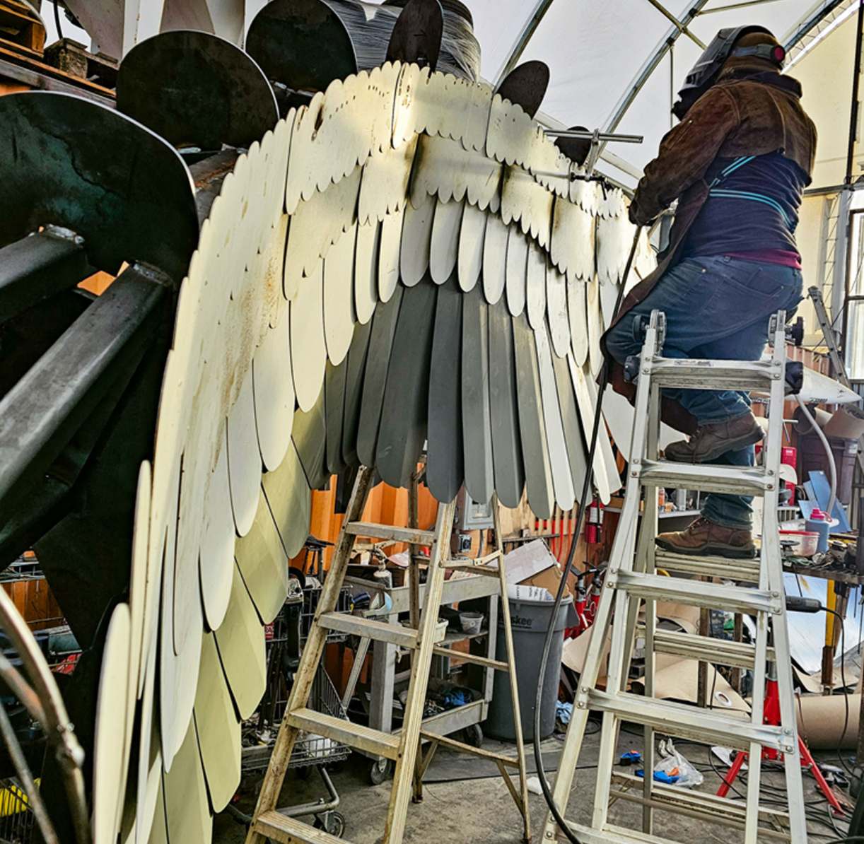 Artist's assistant welds metal 