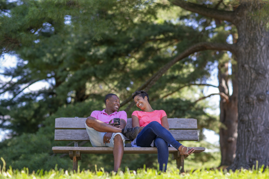 Couple relaxes on a bunch under trees