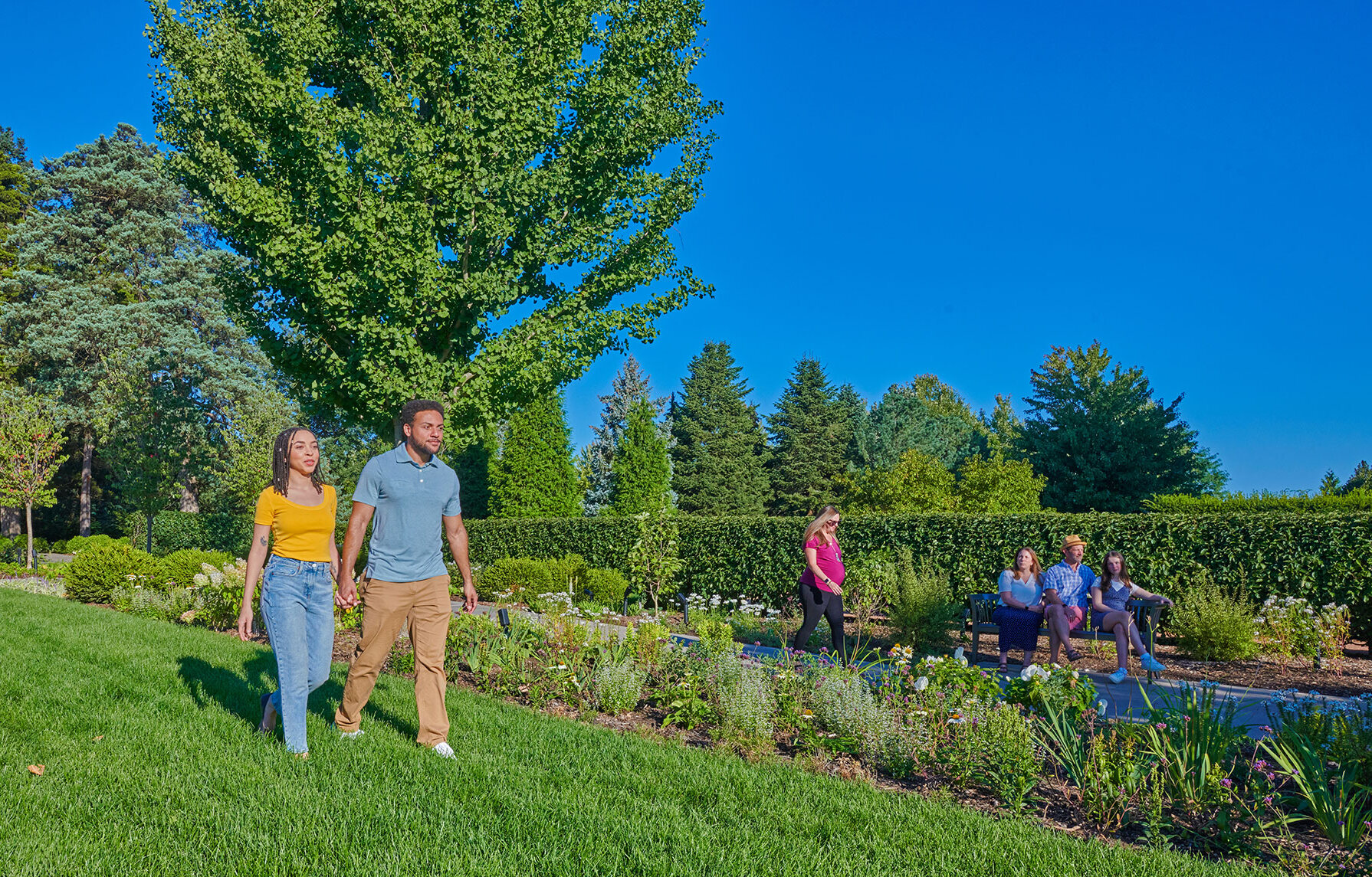 Guests walking and sitting in The Grand Garden on a beautiful summer day