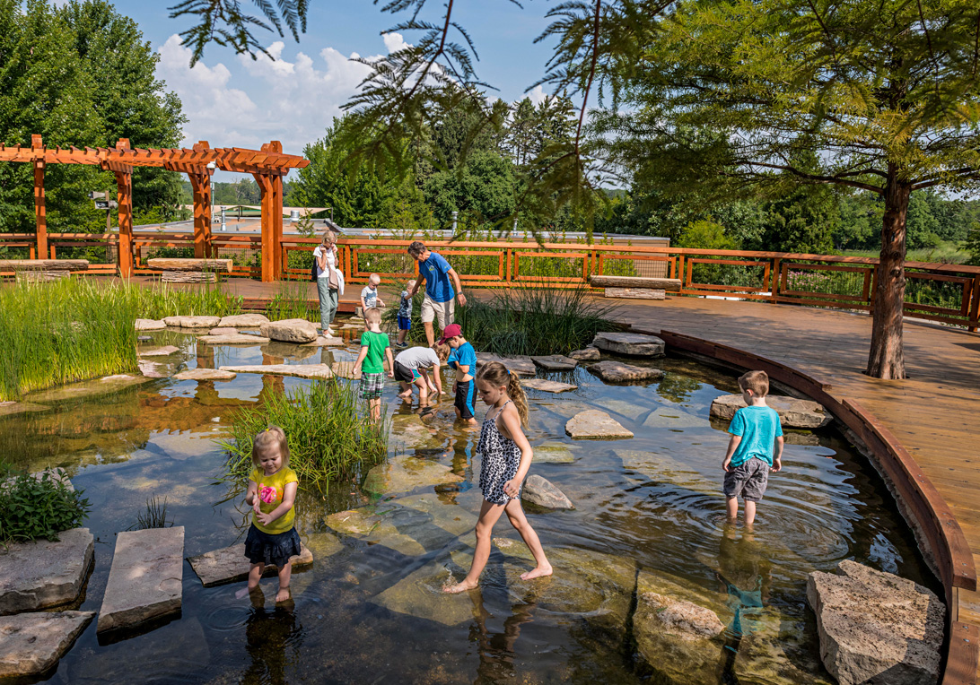 Children playing in the water at Wonder Pond in the Children's Garden.