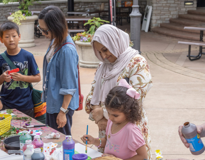 Parents and children create artwork in the children's garden.