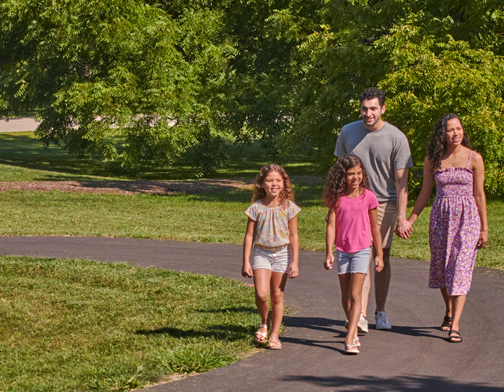 Photograph of family walking through the Arboretum's paved trails in the summer