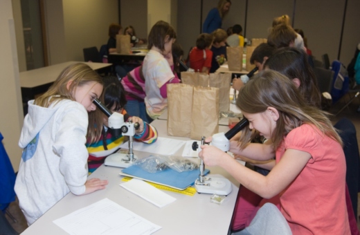 Students using microscopes in a classroom